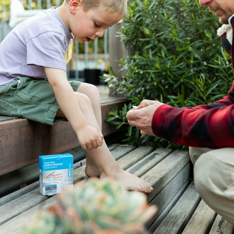 Aero Junior Plasters Putting plaster on child&